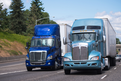 two blue trucks on the road